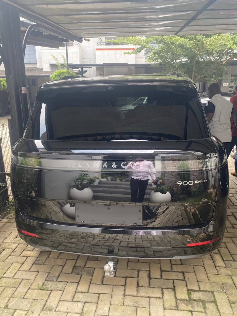 Electric car charging on a paved compound in Abuja