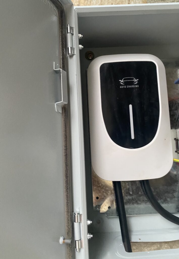 Wall-mounted EV charger installed in a covered parking bay in Abuja