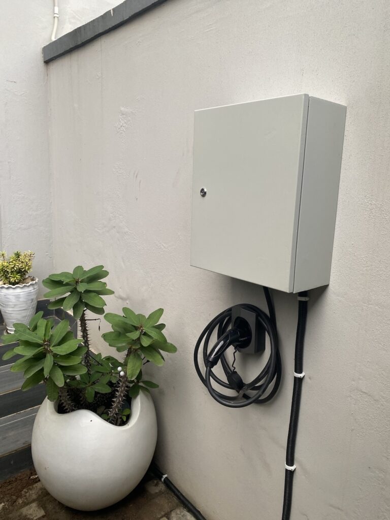 Wall-mounted home EV charger with a coiled Type 2 cable in Abuja